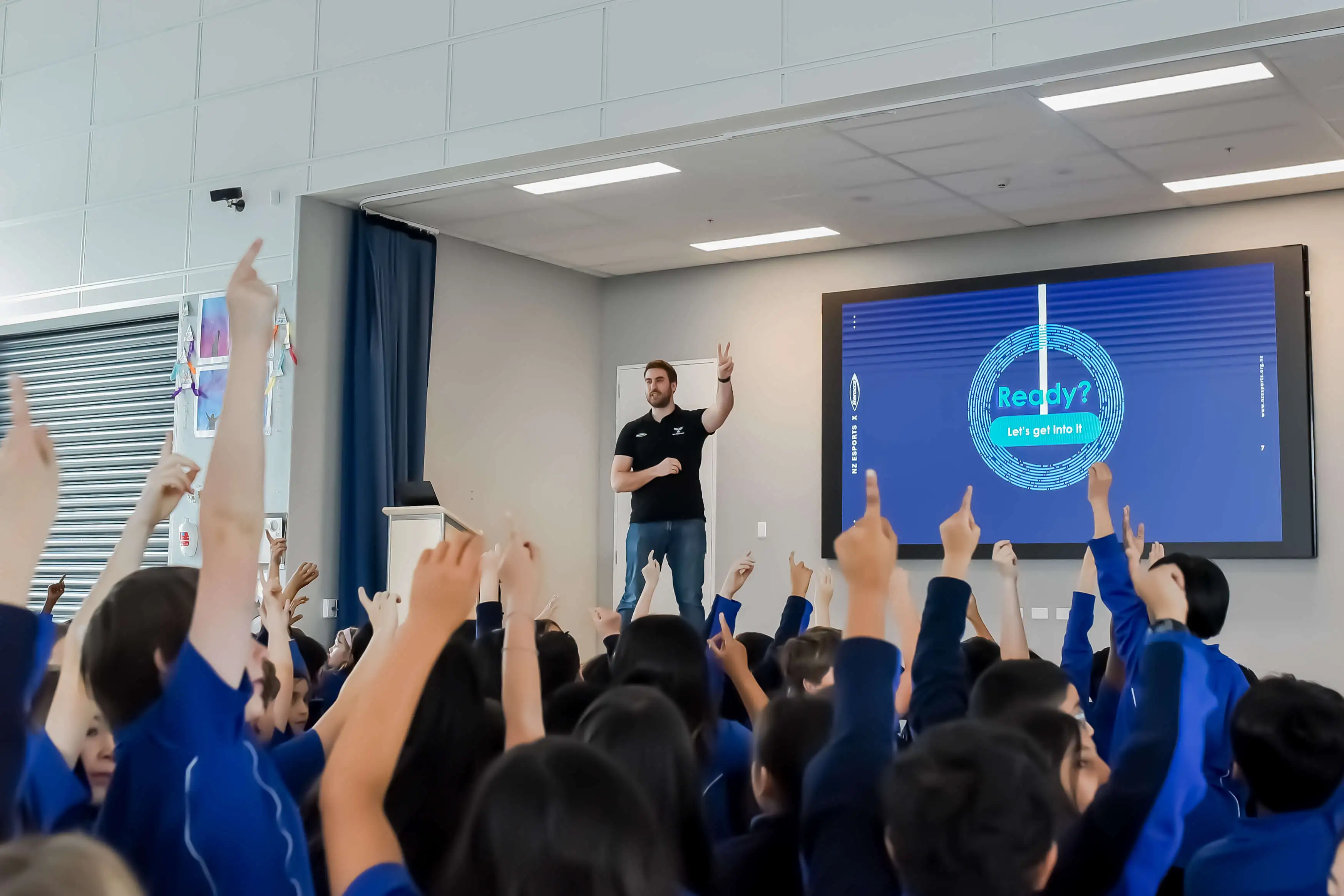 Students raising their hands during an NZ Esports school presentation